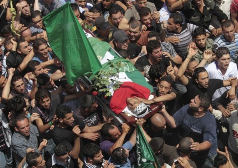 Palestinian mourners carry the body of a man who was killed when Israeli soldiers opened fire on Sunday at protesters.
